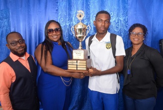 Top business student at the St. Catherine-based José Martí Technical High School, Carlos Evans (second right), receives the Rohan Silvera Business Award Trophy from General Manager at Torpedo Loan, Taskieka Stevenson Allison (second right), at the school, recently. Sharing the moment are (from left) Director at the company, Ronald Reid, and Coordinator of the José Martí Alumni Association New York Inc. (JMAANY) students support programme, Kesha Ford-Walker.

