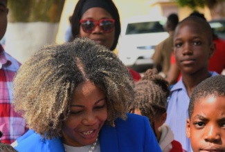 Minister of Education, Skills, Youth and Information, Senator Dr. the Hon. Dana Morris Dixon, interacts with students of Swallowfield Primary and Infant School, prior to the start of a symbolic march from the Ministry at National Heroes Circle to the office of the National Education Trust (NET) at the Caenwood Centre in Kingston on Thursday (February 6). The occasion was NET’s 15th anniversary launch.