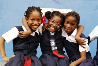Jamaican primary school students smile and pose for the camera