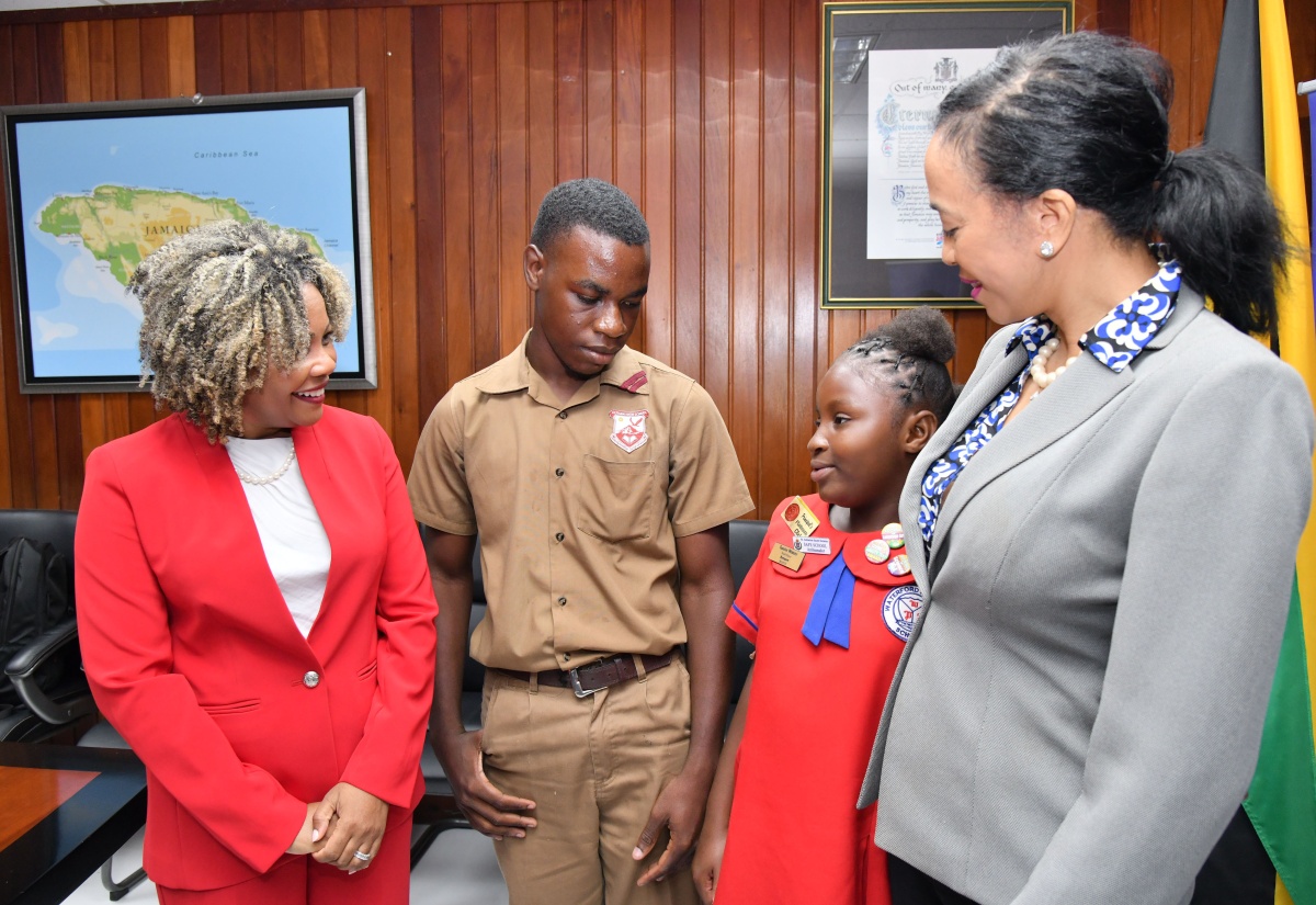 Minister of Education, Youth, Skills and Information, Senator Dr. the Hon. Dana Morris Dixon (left), and Executive Director, American Friends of Jamaica (AFJ) Inc., Caron Chung, share a moment with Eltham High School student Romario Morrison (second left) and Waterford Primary School student Taneice Webster, during the launch of the Reskilling Teachers Using Artificial Intelligence (AI) in STEM Education to Raise Students’ Maths Identity (RAISE) Initiative on Wednesday (March 19). The launch of the programme, which aims to improve mathematics performance across 20 schools, was held at the Education Ministry in Kingston.

