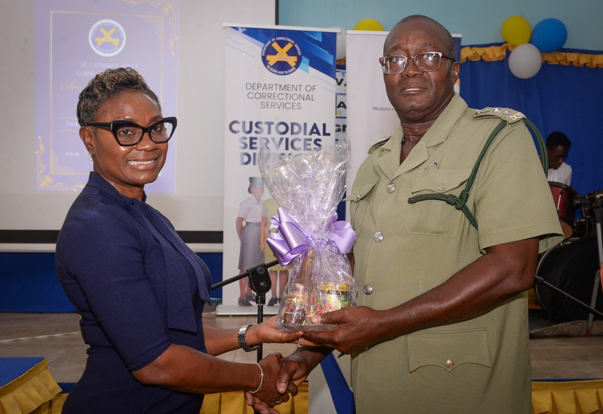 Minister of State in the Ministry of National Security, Hon. Juliet Cuthbert-Flynn (left), receives a token of appreciation from Acting Superintendent of the St. Catherine Adult Correctional Centre, Alfred Whitfield, after addressing an award and recognition ceremony held on Thursday (March 27), at the facility in Spanish Town. The event celebrated the performance of inmates in the Caribbean Secondary Education Certificate (CSEC) examinations, and achievement in areas such as tailoring, welding, and carpentry.