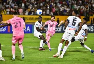 Football legend Lionel Messi (right) strikes the ball during Thursday night’s (March 13) CONCACAF group of 16 match between his Inter Miami CF team from the United States and Jamaica’s Cavalier Football Club, at the National Stadium in Kingston. Inter Miami won the match 2-0.