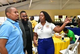 Business Development Officer of Jamaica Dairy Development Board (JDDB), Jody Kay Bowen (right), converses with Minister of Agriculture, Fisheries and Mining, Hon. Floyd Green (left) and Chief Executive Officer (CEO) of JDDB, Devon Sayers (centre), during JDDB’s Dairy Goat Cottage Industry Symposium held at the Kendal Conference Centre in Manchester on Wednesday (March 19).

