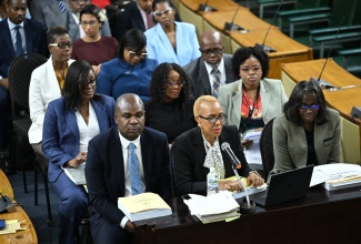 Minister of Finance and the Public Service, Hon. Fayval Williams (centre, front row), provides details on the estimated expenditure for postal and courier services in the upcoming fiscal year 2025/26, at a meeting of the Standing Finance Committee of the House, on Thursday (March 6). She is joined by State Minister in the Ministry of Finance and the Public Service, Hon. Zavia Mayne (left), and Financial Secretary, Darlene Morrison (right), as well as other senior and support staff from the Ministry.

