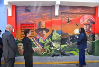 Minister of Foreign Affairs and Foreign Trade, Senator the Hon. Kamina Johnson Smith (second right) and Ambassador of Peru to Jamaica, Mario López Chavarri (left) listen as muralist Michael Elliot (right) highlights features of the mural ‘Meet me in the mountains of Peru’. The artwork was unveiled at the Kingston Art district, downtown Kingston on March 11.

