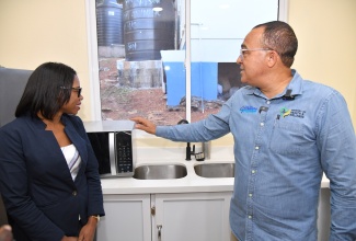 Minister of Health and Wellness, Dr. the Hon. Christopher Tufton (right), points out the features of a microwave to Senior Director of Pharmacy Services at the National Health Fund (NHF), Grace-Ann Johnson, during a tour of the newly refurbished Thompson Town Health Centre in Clarendon, at the official reopening of the facility recently. The improvement work was done under the Ministry’s Operation Refresh initiative, which involves collaboration with the NHF and the regional health authorities.

