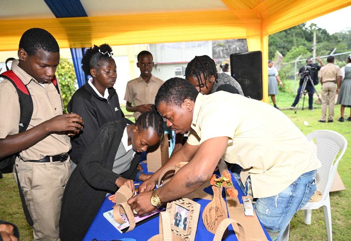 Cardboard Master, Gawayne James, demonstrates how to make art from recycled cardboard to students of Aabuthnott Gallimore High School in Alexandria, St. Ann, during Global Recycling Day activities at the institution on Tuesday, March 18.

