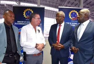 Minister of Science, Energy, Telecommunications and Transport, Hon. Daryl Vaz (second left), in conversation with (from left) Managing Director of the Transport Authority (TA), Ralston Smith; Acting Managing Director of the Jamaica Urban Transit Company (JUTC), Owen Ellington; and Director General of Road Traffic, Island Traffic Authority (ITA), Col. Daniel Pryce. The event was the Ministry’s press conference, held on Tuesday (March 4) at the Half-Way Tree Transport Centre in Kingston.

