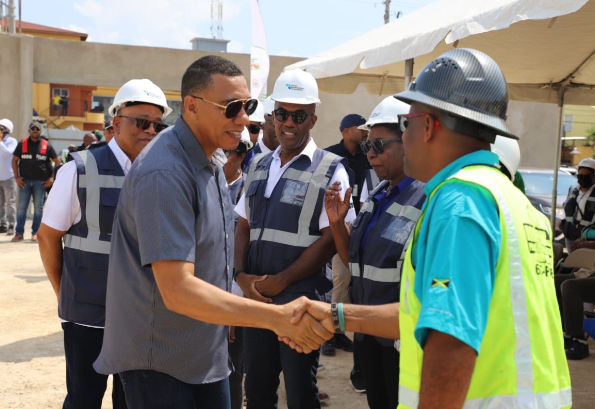 Prime Minister, Dr. the Most Hon. Andrew Holness (second left), is greeted by Pavecon Contractors Limited Managing Director, Brian Singleton, while touring the Portmore Resilience Park project site in St. Catherine on Friday (February 28). Looking on (from left) are Urban Development Corporation (UDC) Chairman, Norman Brown, Deputy General Manager, Sherlock Glenister, and Chief Architect, Maxine Fisher-Casserly. The Park’s development is being spearheaded by the UDC.