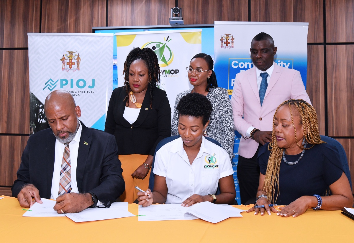 Director General of the Planning Institute of Jamaica (PIOJ), Dr. Wayne Henry (seated left), and Founder/Executive Director of Young Women of Purpose (YWOP)/Young Men of Purpose (YMOP), Lanisia Rhoden (seated second left), sign a contract for the training of 50 entrepreneurs under the Realise, Embrace, Achieve Your Purpose (REAP) Entrepreneurship Programme, at the PIOJ offices in Kingston on Monday (March 17). Observing are Human Resource Director, PIOJ, Sandra Ward (seated front, right); and (standing from left) are Technical Specialist, PIOJ, Charmaine Brimm; Chief Technical Director, Ministry of Industry, Investment and Commerce, Latoya Richards Franklin; and Senior Programmes, Apprenticeship/Micro, Small and Medium-sized Enterprises (MSMEs) Support Unit Director, HEART/ NSTA Trust, Marlon Johnson.

