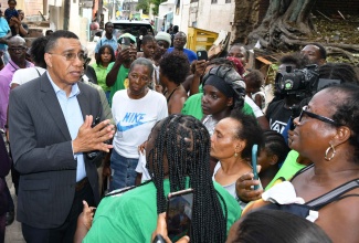 Prime Minister, Dr. the Most Hon. Andrew Holness, addresses residents of Kingston Central during Tuesday’s (March 4) tour of communities affected by a recent fire which displaced a number of householders. At right is Member of Parliament for the constituency and Minister of Local Government and Community Development, Hon. Desmond McKenzie.