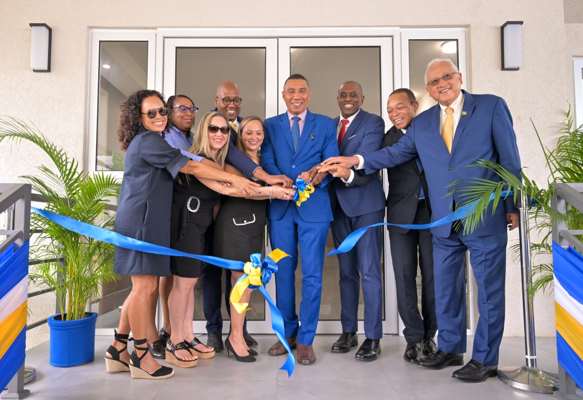 Prime Minister, Dr. the Most Hon. Andrew Holness (fourth right), cuts the ribbon symbolising the official opening of The Nitrams of Waterloo, located at 44 Upper Waterloo Road in St. Andrew, on March 25. He is joined by (from left, front row): daughters of developer of The Nitrams of Waterloo, the late Philip Martin and directors of Nitram Developments Limited, Wendy Martin Haddad; Kathy Greaux; Anna-Kaye Martin-Shirley; General Manager, Jamaica Mortgage Bank, Courtney Wynter; Senior Vice President, Corporate Banking and SME Business Banking, Sagicor Bank Jamaica, Michael Willacy; Minister of Justice and Member of Parliament, St. Andrew North Eastern, Hon. Delroy Chuck. Also at the opening are (second row): Director, Business Operation, Jamaica Mortgage Bank, Patricia Burke; and Acting Chairman, Jamaica Mortgage Bank, Ryan Parkes.

