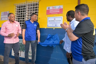 Prime Minister, Dr. the Most Hon. Andrew Holness (second left), unveils the sign denoting the Mason Hall Water Supply project in St. Mary,  following Friday
