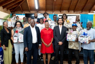 Project Manager, Food and Agriculture Organization of the United Nations (FAO), Vanessa Oates (left); Executive Director, Bureau of Standards Jamaica (BSJ), Dr. Velton Gooden (third left); Project Focal Point, BSJ, Tafara Smith (centre); and Project Donor Representative from the Standards and Trade Development Facility (STDF), Pablo Jenkins, with hot pepper farmers holding packages of farming equipment and other implements during the ‘Improving Phytosanitary, Food Safety and Market Access Opportunities along the Hot Pepper Value Chain in Jamaica’ project handover ceremony, on Monday (April 28), at the Kingston offices of theBSJ.