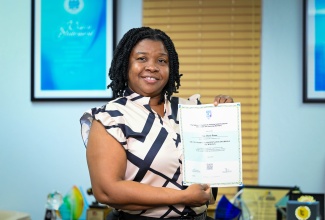 Security Officer, Ann-Marie Brown, displays her certificate in Air-Conditioning Technology at the headquarters of the HEART/NSTA Trust, on Oxford Road in St. Andrew, recently.

