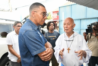 Prime Minister, Dr. the Most Hon. Andrew Holness (left), listens to a point being made by Founder, Missionaries of the Poor, Father Richard Ho Lung, when he visited the charity organisation on Tower Street in downtown Kingston on Wednesday (April 16).