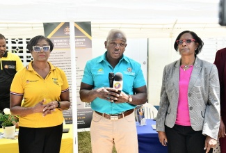Minister of Labour and Social Security, Hon. Pearnel Charles Jr., speaks to journalists during a tour of the Ministry’s satellite office at the Castleton Health Centre in St. Mary on Wednesday (April 23). With the Minister are (from left), the Ministry’s St. Mary Parish Office Manager, Charmaine McFarlane, and Acting Permanent Secretary, Dion Jemmings.

