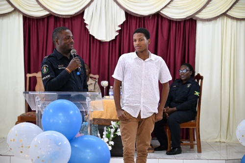 Student of Rhodes Hall High School in Hanover, Rushawn Legister (right), listens as police officer attached to the Hanover Community Safety and Security Branch (CSSB), Constable Errol Walters, applauds his positive transformation during the ‘I Have Triumph’ Award Ceremony held at the Christian Fellowship Church in Lucea, Hanover, on Saturday (March 29).