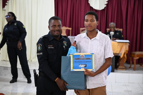 Student of Rhodes Hall High School in Hanover, Rushawn Legister (right), accepts his award from police officer attached to the Hanover Community Safety and Security Branch (CSSB), Constable Errol Walters, during the ‘I Have Triumph’ Award Ceremony held at the Christian Fellowship Church in Lucea, Hanover, on Saturday (March 29).