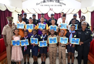 Police officers attached to the Hanover Community Safety and Security Branch (CSSB) stand with student awardees of the ‘I Have Triumph’ Award Ceremony held at the Christian Fellowship Church in Lucea, Hanover, on Saturday (March 29).