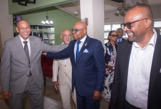 Minister of Tourism, Hon. Edmund Bartlett (second right) greets Deacon and Chairman of Evangelism and Missions, Kingston Open Bible Church, Eric Hosin (left) at the Jamaica Tourist Board (JTB) 70th anniversary church service held at the Church of the Open Bible in Kingston on April 6. Looking on are President of the Jamaica Hotel and Tourist Association (JHTA), Robin Russell (second left) and Director of Tourism, Donovan White.