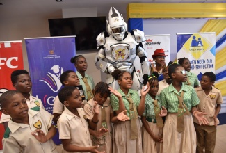 Students from the Excelsior Primary and Infant School share a photo opportunity with the robot ‘Captain I Can’ during the media launch of Child Month 2025 on April 10 at GraceKennedy Limited in Kingston under the theme ‘Act Now: Stand Against Child Abuse and Exploitation’.

