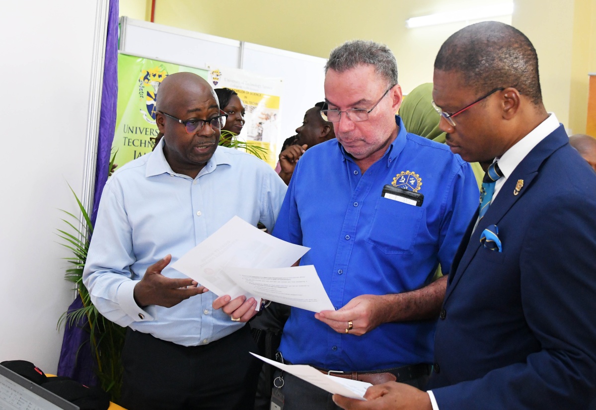Science, Energy, Telecommunications and Transport Minister, Hon. Daryl Vaz (centre) peruses a document with University of Technology Jamaica (UTech) President, Dr. Kevin Brown (right), and Chief Category Manager, Hardware and Lumber Limited, Patrick Chambers. The event was the UTech Jamaica’s Research, Technology and Innovation Day held on Thursday (April 10) at the institution’s Old Hope Road location.