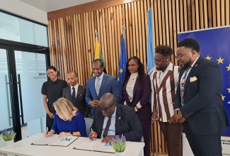Head of the European Union Delegation to Jamaica, Belize and the Bahamas, Her Excellency, Dr. Erja Askola (left seated) and United Nations (UN) Resident Coordinator in Jamaica, Dennis Zulu (right seated) sign the UN-EU Youth Advisory Group (YAG) Agreement at the European Union Delegation’s office in Kingston today (April 8). Witnessing the signing are Minister of State in the Ministry of Foreign Affairs and Foreign Trade, Alando Terrelonge (third left); Acting Senior Director in the Youth and Adolescents Policy Division at the Youth Ministry, Yanique Williams (third right), and members of the YAG.

