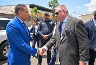 Prime Minister, Dr. the Most Hon. Andrew Holness (left), is greeted by Chairman, Jamaica Packaging Industries (JPI), Conrad George, during the JPI’s 70th anniversary and grand opening ceremony for its new factory located at 693 Spanish Town Road in Kingston, on April 29.