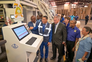 Prime Minister, Dr. the Most Hon. Andrew Holness (second left), starts the newly installed corrugator machine at the Jamaica Packaging Industries (JPI) Limited, during the opening of the company’s US$12.75-million state-of-the-art manufacturing facility at 693 Spanish Town Road in Kingston, on April 29.  Observing  (from left) are Country Manager, JPI, Gary Cole; Chairman, JPI, Conrad George; Operations Manager, JPI, Oswin Thomas; shareholder, Susan Rowett and her son, John Rowett (in background).