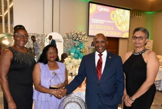 Minister of Industry, Investment and Commerce, Senator the Hon. Aubyn Hill (second right), is greeted by Technical Consultant with the Environmental Health Laboratory (EHL), Nilsia Johnson (second left), at the recent accreditation ceremony for EHL, held at the AC Mariott Hotel in New Kingston. Others pictured (from left) are Chief Executive Officer of the Jamaica National Agency for Accreditation (JANAAC), Dr. Yvette Castell, and Director of the National Public Health Laboratory (NPHL), Dr. Marlene Tapper.