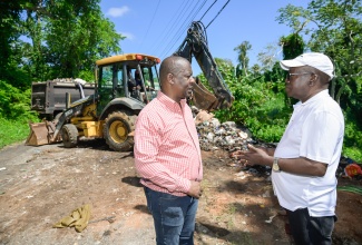 Mayor of Mandeville, Councillor Donovan Mitchell (left), engages in discussion with Parochial Inspector at the Manchester Municipal Corporation, Derick Bailey (right), during the removal of a mini dump site at Patrick Road in Mandeville on Friday (May 23). The area was also beautified. The activity formed part of the parish’s Labour Day project under the theme ‘Protect the Environment: Our Land, Our Duty, Our Future and the accompanying slogan ‘Jamaica Nice, Protect Wi Paradise’.


