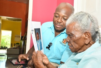 Minister of Labour and Social Security, Hon. Pearnel Charles Jr. (left) shares in a light moment with 100-year-old, Ruby Brooks, at her home in Mitchell Town, Clarendon on May 16. As part of the activities to observe National Centenarians’ Day Tuesday, May 20, 2025, the Ministry of Labour and Social Security, through the National Council for Senior Citizens (NCSC), has embarked on a series of special visits across the island to honour Jamaica’s oldest citizens.
