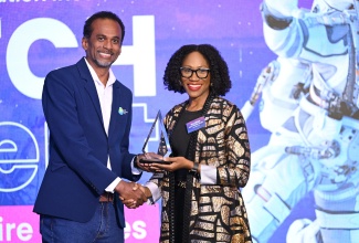 Executive Director, Tourism Enhancement Fund (TEF), Dr. Carey Wallace, presents Founder, JamLegend VR, Nadeen Matthews Blair, with the winning award in the 2025 Tourism Innovation Incubator Pitch event at the AC Hotel by Marriott Kingston on Friday (May 2).