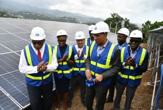 Prime Minister, Dr. the Most Hon. Andrew Holness (front), cuts the ribbon to commission into service the Forest Hill Solar Park in Forest Hill, St. Andrew, on Tuesday (May 27). He is joined by (back, from left) Member of Parliament for St. Andrew Western, Anthony Hylton; Minister of State in the Ministry of National Security and Member of Parliament for St. Andrew West Rural, Hon. Juliet Cuthbert-Flynn; Minister without Portfolio in the Ministry of Economic Growth and Job Creation, Hon. Matthew Samuda; Energy Manager at the National Water Commission (NWC), Haniffe Morrison; Acting Vice President of Operations at the NWC, Herman Fagan; and Member of Parliament for St. Andrew North Western, Duane Smith.