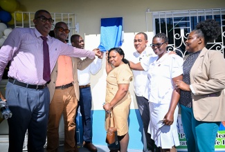 Minister of Health and Wellness,  Dr. the Hon. Christopher Tufton (third right), is joined by staff from the Southern Regional Health Authority and other officials as he unveils the plaque on the wall at the newly refurbished Aenon Town Health Centre in Clarendon, on May 8.
