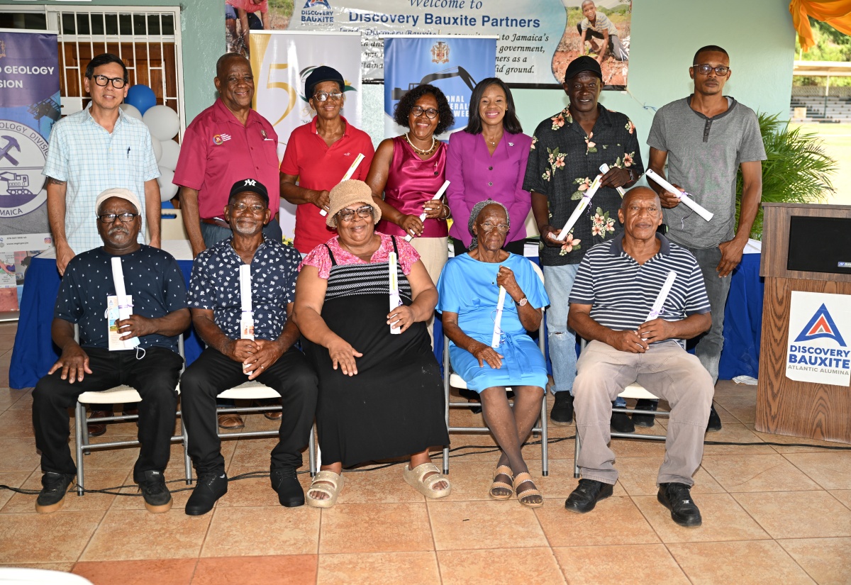 State Minister in the Ministry of Agriculture, Fisheries and Mining, Hon. Franklin Witter (second left, back row), and Acting Vice President & General Manager of Discovery Bauxite Partners, Christopher Cargill (left, back row), with recipients of certificates of title, at the Bauxite Land Titling & Subdivision Permitting Conference, held at Port Rhoades Sports Club (Discovery Bauxite) in St. Ann, on Monday, May 26.