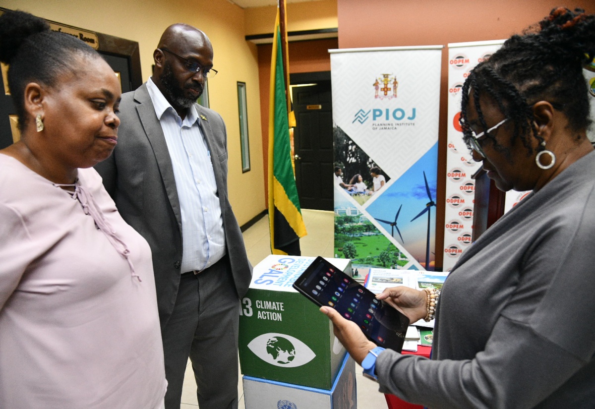 Acting Deputy Director General at the Office of Disaster Preparedness and Emergency Management (ODPEM), Michelle Edwards (right), looks at one of 25 tablet computers handed over on Monday (April 28) at ODPEM’s Kingston office, which will assist in Initial Damage Assessment (IDA). Looking on are Acting Senior Director of Preparedness and Emergency Operations, ODPEM, Sophia Mitchell (left), and Director General of ODPEM, Richard Thompson. These tablets, procured by the Planning Institute of Jamaica (PIOJ) under the Adaptation Fund, will facilitate immediate collection, uploading and conveyance of damage assessment data for relief and response coordination through the National Emergency Operations Centre (NEOC).

