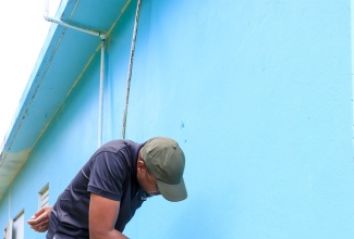 Minister without Portfolio in the Ministry of Economic Growth and Job Creation and Member of Parliament for Clarendon North Central, Hon. Robert Morgan, paints the exterior walls of the Summerfield Community Centre in Chapelton, during Labour Day activities on Friday (May 23).  The Minister led several projects across the constituency that focussed on community development, education, and youth empowerment.

