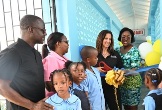 Director of Operations at the Sandals Foundation, Karen Zacca (second right), leads the ribbon-cutting exercise marking the official opening of the ‘Word Alley’ at Salt Spring Primary and Infant School in St. James on Read Across Jamaica Day, May 6. She is joined by (from left) the school's Board Chairman, Conrad Thomas; Principal, Norma Brydson; Parent-Teacher Association (PTA) President, Latoya Clarke-Wilson, and students.