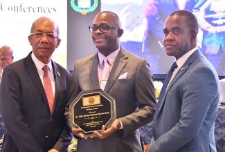 Minister of National Security, Hon. Dr. Horace Chang (left), and Commissioner of Police, Dr. Kevin Blake (right), with retired Sergeant, Milton Henry, who was given a special award by the Jamaica Police Federation at its 82nd Joint Central Conference, which was held at the Princess Grand Hotel in Hanover on Tuesday (May 27).

 