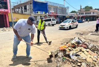 Mayor of Montego Bay, Councillor Richard Vernon (right), and Deputy Mayor, Councillor Richard Crawford, participate in Labour Day clean-up activities outside the Charles Gordon Market in Montego Bay, St. James, on Friday (May 23). The initiative forms part of the parish project, which focused on revitalising the market district under the national slogan