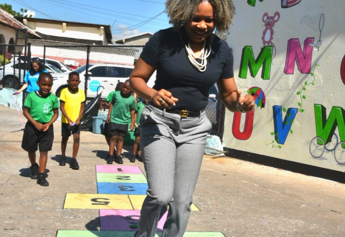 Minister of Education, Skills, Youth and Information, Senator Dr. the Hon. Dana Morris Dixon, participates in a game of hopscotch during a visit to Calabar Infant, Primary and Junior High School in Kingston, in observance of National Children’s Day on Friday (May 16).
