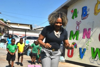 Minister of Education, Skills, Youth and Information, Senator Dr. the Hon. Dana Morris Dixon, participates in a game of hopscotch during a visit to Calabar Infant, Primary and Junior High School in Kingston, in observance of National Children’s Day on Friday (May 16).
