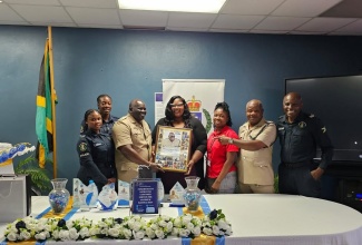 Former Commanding Officer for the Trelawny Police Division, Retired Superintendent, Winston Milton (third left), receives a plaque from members of his team. The retired police officer was honoured during a ceremony on April 28.