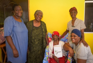 Jamaica’s oldest centenarian, 108-year-old Iris Duffus (centre), is flanked by (from left) Granddaughter, Erona Stephenson; Daughters, Lawner Stephenson and Helena Anderson; and Great-granddaughter, Maxine McGann-Davis, at her Brivate, Frazers Content, St. Catherine home.

