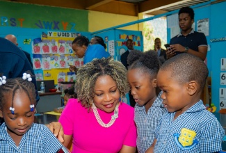 Minister Dana Morris Dixon shares a joyful moment reading to students of Constitution Hill Primary and Infant School during Read Across Jamaica Day.

