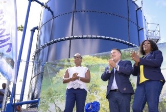 Minister without Portfolio in the Ministry of Economic Growth and Job Creation, Hon. Matthew Samuda (centre), applauds during the commissioning of a 50,000-gallon steel tank in Mount Prospect, St. Andrew on Thursday (March 8), which will bring reliable access to potable water to residents of several communities. He is joined by Minister of State for National Security and Member of Parliament for St. Andrew West Rural, Hon. Juliet Cuthbert Flynn (left) and National Water Commission (NWC) Acting Vice President of Operations, Dr. Phillipa Campbell-Francis.