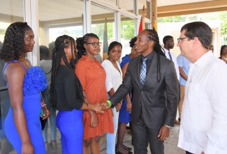 State Minister in the Ministry of Foreign Affairs and Foreign Trade, Hon. Alando Terrelonge (second right), greets Scholarship Recipient for Accounting, Capeech Watkins (second left); Scholarship Recipient for Veterinary Medicine, Saunshay Smiley (left); and Scholarship Recipient for Nursing, Cassandra Davy (third left). Looking on is Cuba’s Ambassador to Jamaica, His Excellency Fermín Quiñones Sánchez (right). The interaction took place during the awards ceremony for the Cuba-Jamaica Bilateral Scholarship Programme, held on Wednesday (May 28) at the Embassy of Cuba in Kingston.
