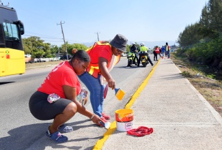 Ibex volunteers, Sourcing Specialist, Sharlene Wilson (left) and Talent Acquisition Manager, Britannia Bennett (right), paint a section of the newly erected sidewalk along George Lee Boulevard in Portmore on Friday (May 23) which forms part of the Portmore Municipal Corporation’s Labour Day Project. The Corporation is also carrying out tree-planting activities in the community of Portsmouth, which aligns with this year’s Labour Day theme, ‘Protect the Environment: Our Land, Our Duty, Our Future’ and slogan ‘Jamaica Nice, Protect Wi Paradise’.


